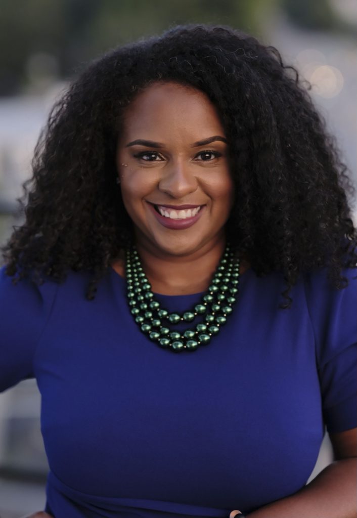 Headshot of Andrea Jackson Gavin wearing a multi-layered necklace and blue shirt.